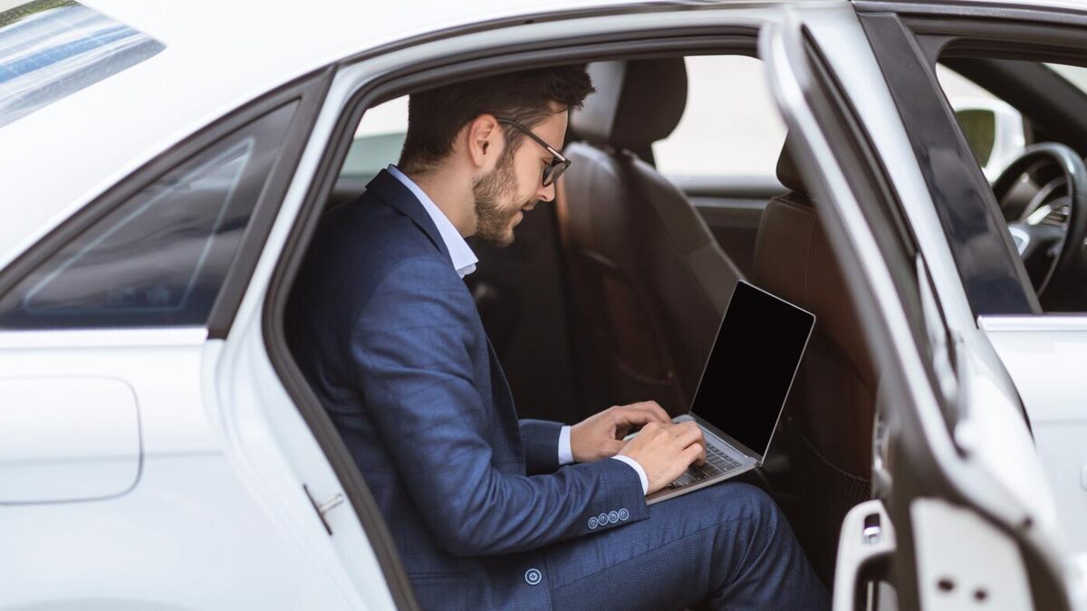 Ejecutivo trabajando con su computador durante el traslado